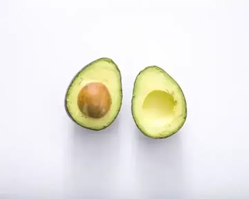 an avocado cut in half on a white background